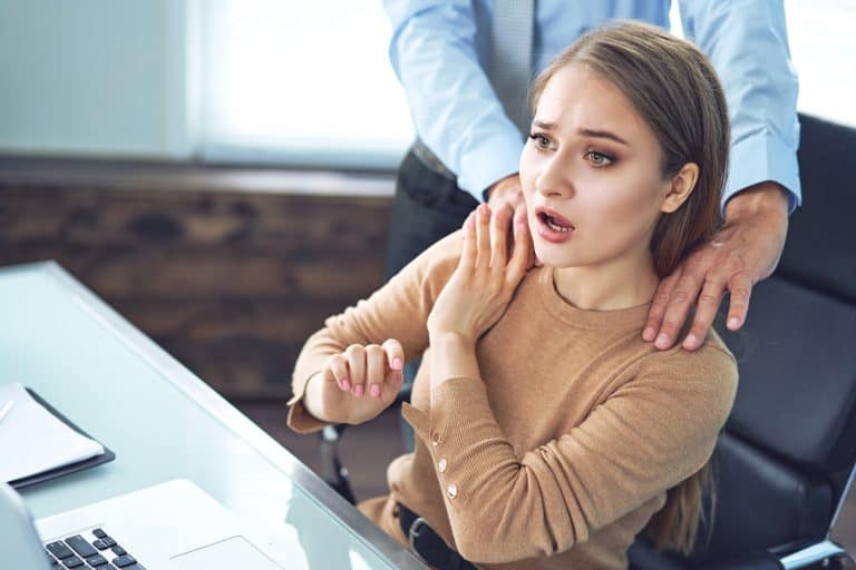 Businessman is Sexually Harassing Female Colleague by Touching Her Shoulder